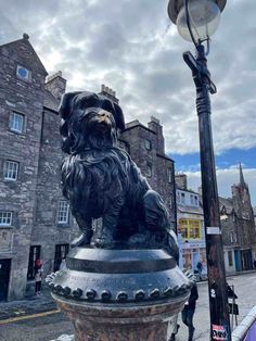 a statue of a dog sitting on top of a lamp post