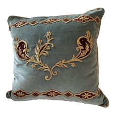 a blue pillow with gold embroidered designs on it