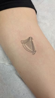 a small harp tattoo on the arm