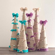 three small christmas trees made out of burlocks with bows and ribbons on them