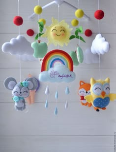 a mobile with animals hanging from it's sides in the shape of rainbows and clouds