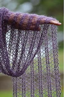 a purple net hanging from the side of a tree