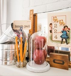 there are many items on the shelf in this room, including apples and pencils