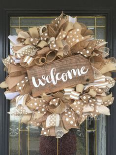 a welcome sign is hanging on the front door with burlocks and polka dots