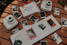 an open book with pictures and a camera sitting on top of it next to a table