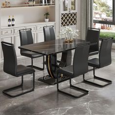 a dining room table with black chairs around it