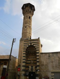 a tall tower with a clock on it's side in the middle of a street