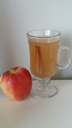 an apple sitting next to a cup of tea