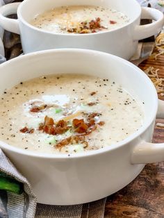 two white bowls filled with soup on top of a table