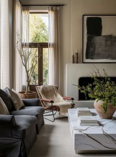 a living room filled with furniture and a fire place in front of a painting on the wall