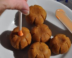 a person is dipping something into some food on a white plate with spoons and utensils