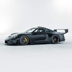 a black sports car parked on top of a snow covered field in front of a white background