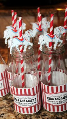 there are many glass bottles with paper straws in them on the counter next to each other