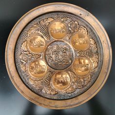 an ornate brass plate with six gold medallions