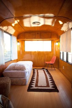 a bedroom with a bed, chair and rug in the corner next to two windows