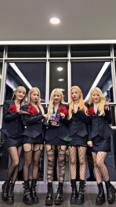 four women dressed in black and red posing for the camera with roses on their chests