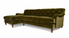 a green velvet sectional sofa with wooden legs and foot rests on an isolated white background