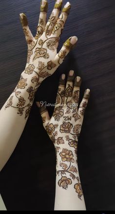 two hands with henna tattoos on them