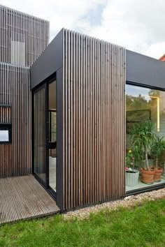 an image of a small house made out of wood planks and metal slats