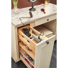 an open drawer in a kitchen next to a clock and other items on the counter