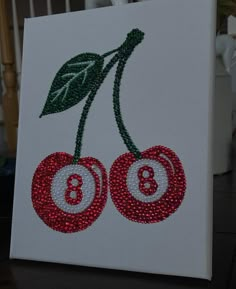 two cherries on a white canvas with green leaves and numbers 8 - 9 in the center