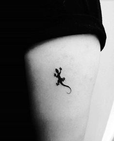 a small lizard tattoo on the right side of the thigh, it is black and white