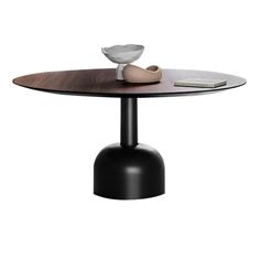 an oval table with a black base and a white bowl on top, in front of a white background