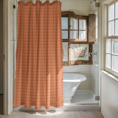 an orange shower curtain hanging in front of a bathtub