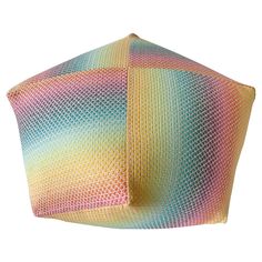 a multicolored pillow sitting on top of a white surface