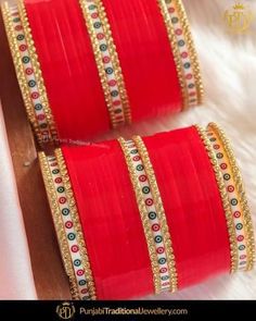 two red and gold colored bangles on white furnishing