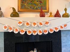 a mantel decorated with fall leaves and vases on top of it in front of a fireplace