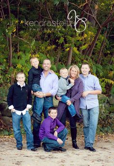 a family posing for a photo in front of some trees