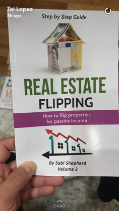 a person holding up a real estate flipping book