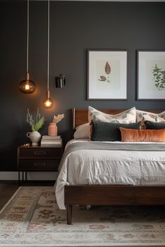 a bed sitting in a bedroom next to two pictures on the wall and lamps hanging above it