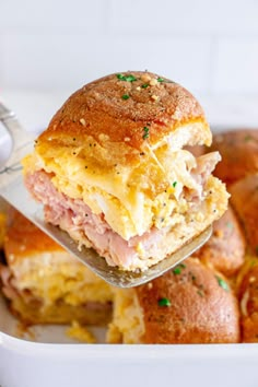 ham and cheese sandwich being lifted from a casserole dish