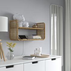 a shelf with books and other items on it next to a lamp in a room