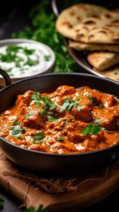 a pan filled with meat and sauce next to pita bread