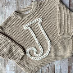 This knit can have any letter, name, phrase or number on it. It is a simple classy look, perfect for the "less is more" look! I am happy to come up with any style you like, just message me!  Each sweater is hand-embroidered and truly one-of-a-kind, with every stitch crafted meticulously to ensure perfection.Thank you for choosing Elora By Lenore to create your special piece! Head over to Instagram @elorabylenore for all the latest design updates and lots more customer reviews! Baby Jumpers, Minimal Baby, Name Sweater, Baby Jumper, Unique Name, Spirit Wear, Stylish Kids, Kids Sweater, Less Is More