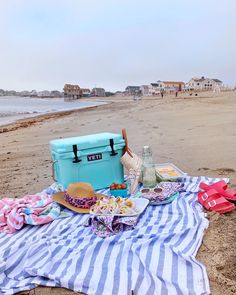 a picnic on the beach with food and drinks