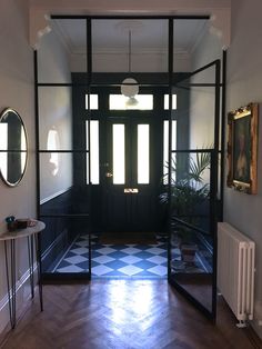 an entry way with black and white checkered flooring, two round mirrors on the wall