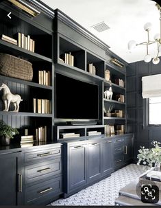 a living room with bookshelves and a television on the wall in front of it