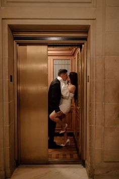 a man and woman kissing in an elevator