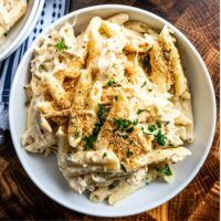 two bowls filled with pasta on top of a wooden table