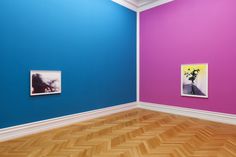 an empty room with two paintings on the wall