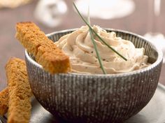 a bowl filled with cream cheese and crackers on top of a black saucer