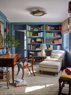 a living room filled with furniture and bookshelves next to a painting on the wall