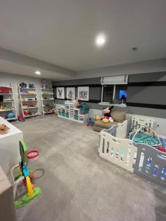 a large room with two cribs and lots of toys