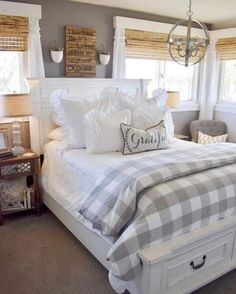 a white bed sitting in a bedroom next to two windows