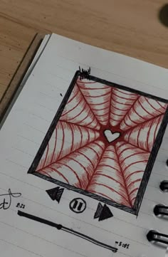 a drawing of a spider web on top of a notebook