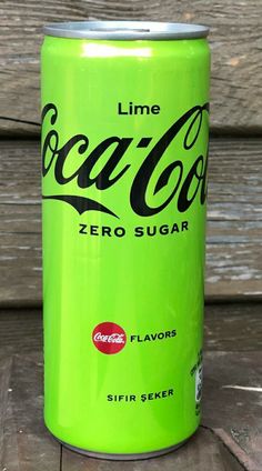 a can of coca cola sitting on top of a wooden table